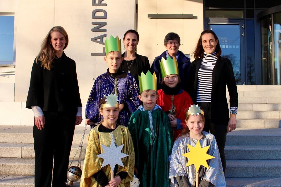 Mehrere Kinder, die als Sternsinger verkleidet sind, sowie Begleitpersonen stehen vor dem Landratsamt.