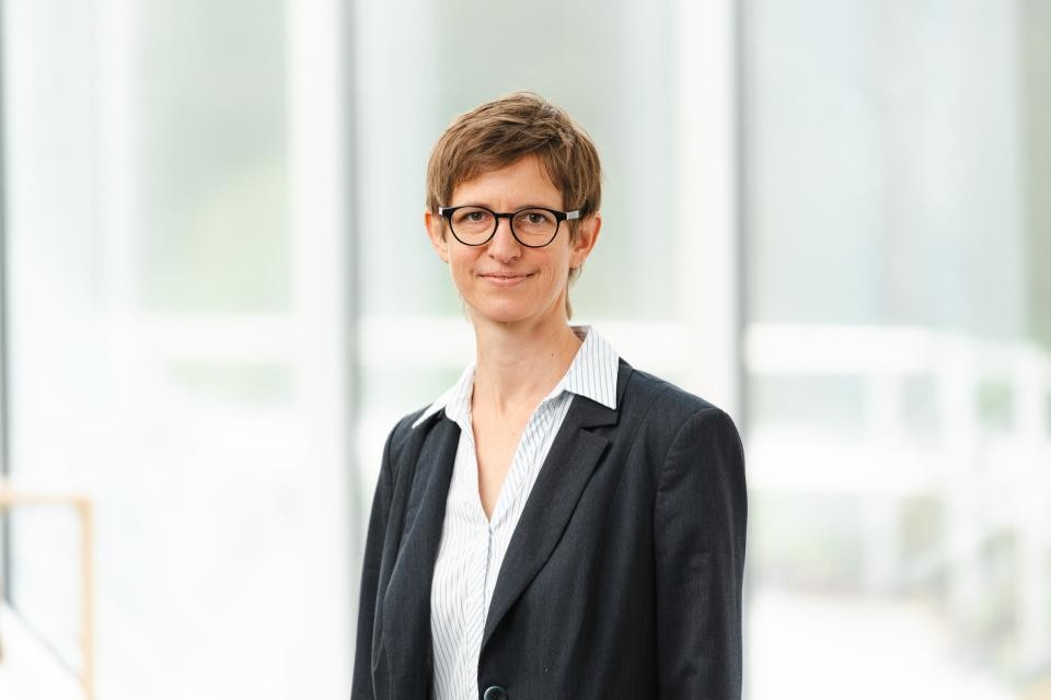 Eine Frau mit einer Brille und kurzen braunen Haaren.